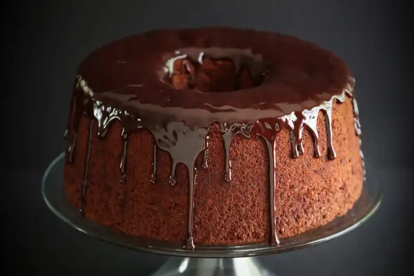 Delizioso chiffon cake al cioccolato con glassa fondente che cola.